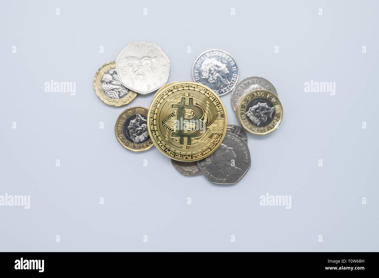 Physisches Gold Bitcoin auf normales altes englisches Geld Stockfoto