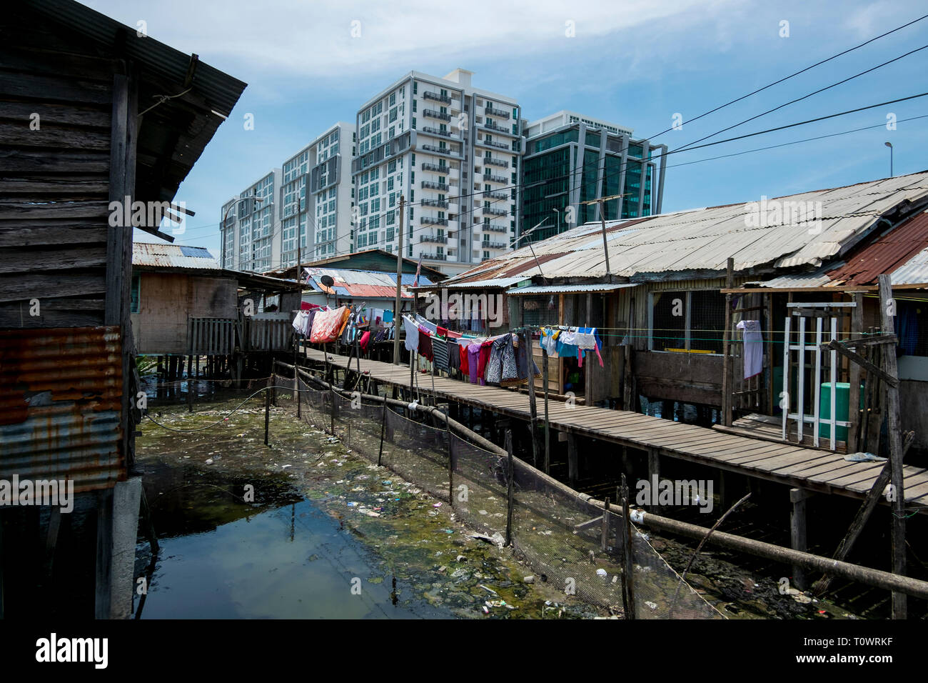 Einem traditionellen Stelzenhaus wasser Siedlung sitzt vor der modernen Entwicklung in Kota Kinabalu, Sabah, Borneo, Malaysia. Stockfoto