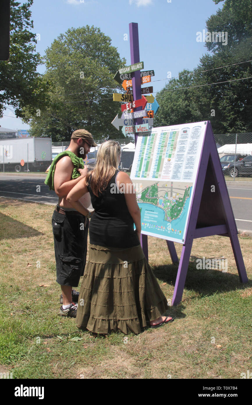 Konzertbesucher werden angezeigt, das Anzeigen der festival Karte und band Spielplan während einer Outdoor Event. Stockfoto