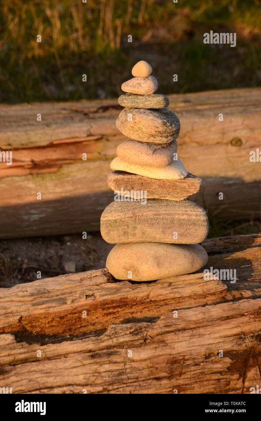 Haufen von Steinen Balancieren auf einem Holz anmelden. Stockfoto