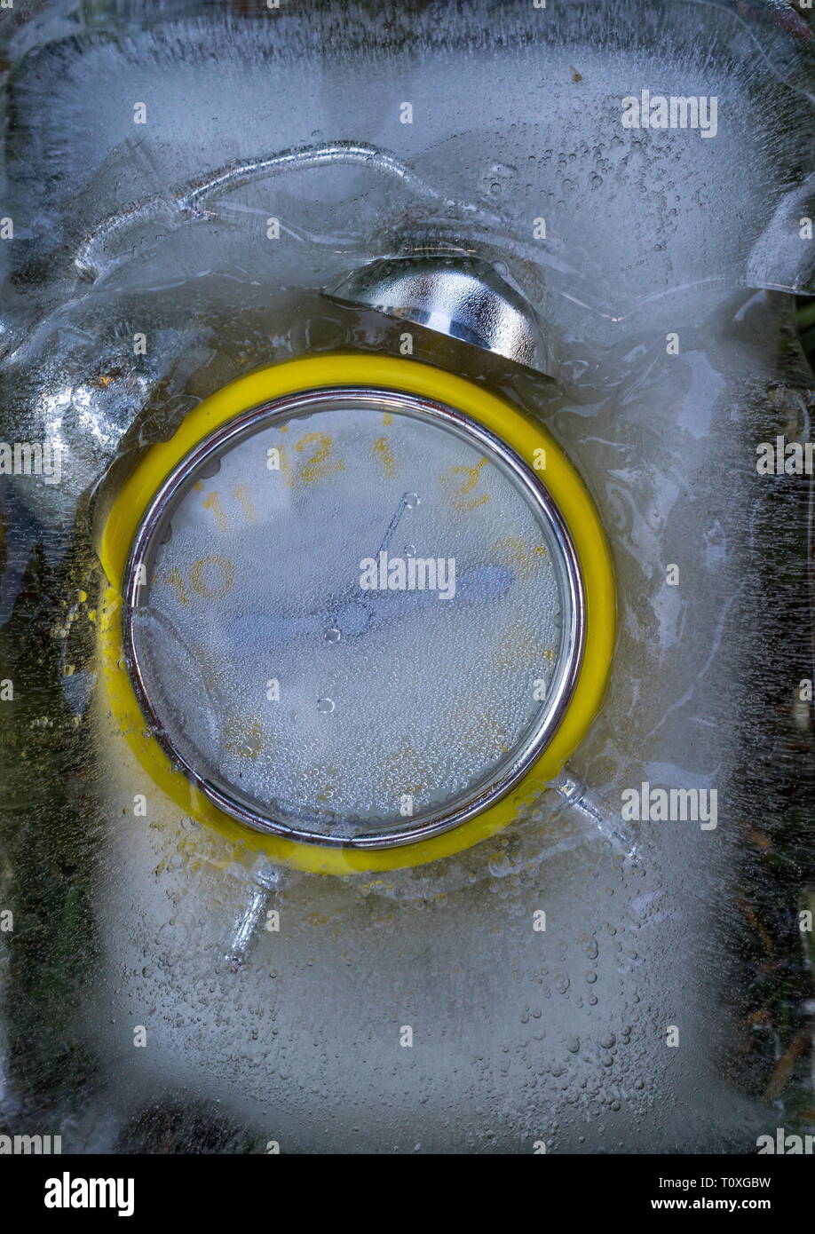 Retro gelb Wecker in einem eisblock Bild mit Kopie Raum gefroren Stockfoto