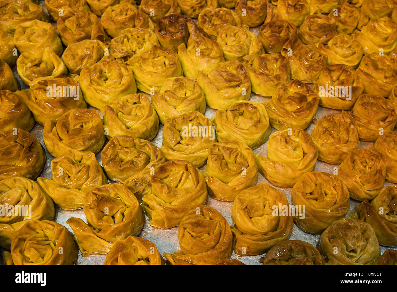 Nahaufnahme von einem Fach mit frisch gebackenem süßen Brötchen. Lecker und appetitlich zuckerhaltigen Festlichkeiten auf Bäckerei. Süßwaren Store verkaufen bräunlich Pas Stockfoto