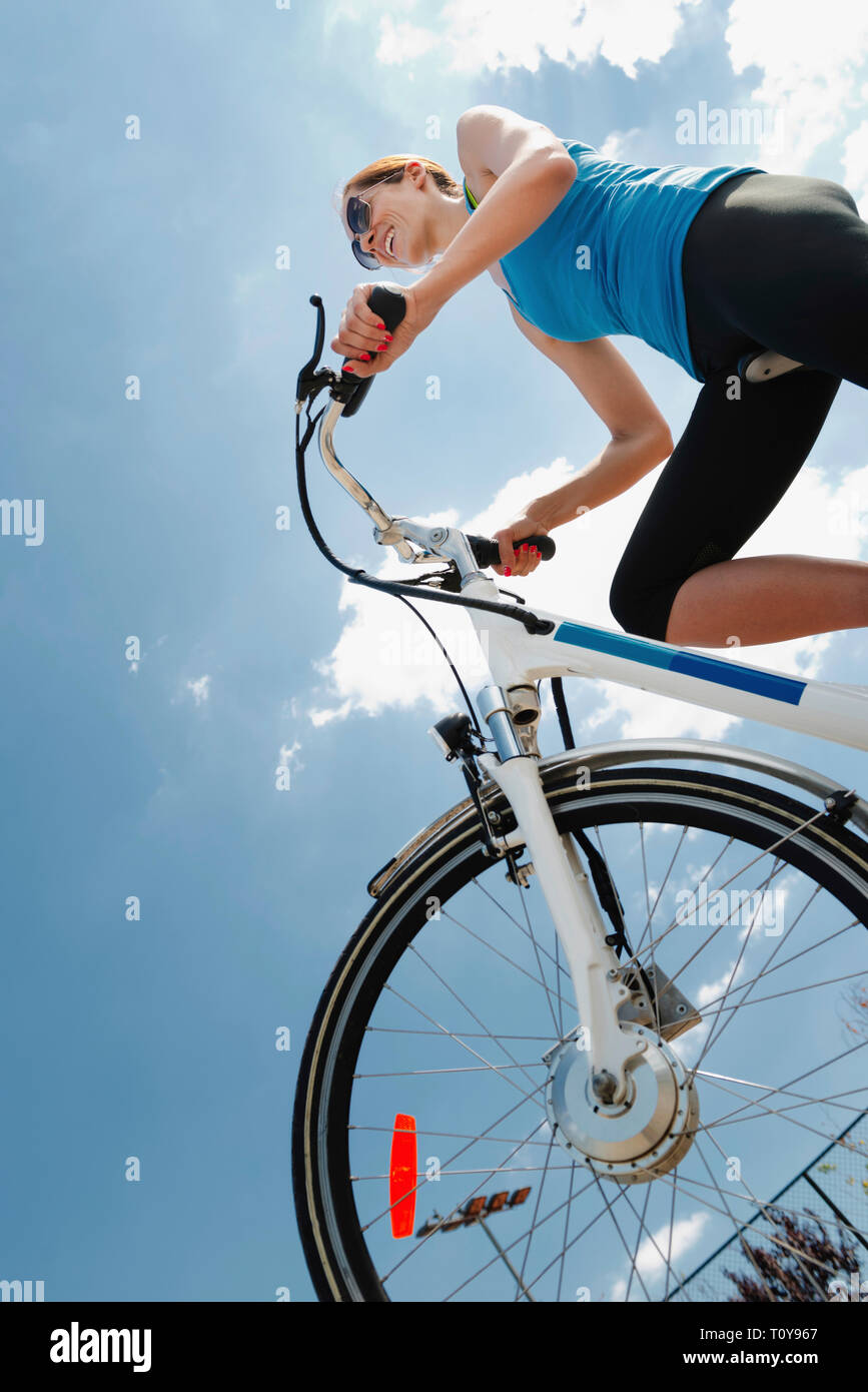 Junge Frau reiten Elektrofahrrad Stockfoto