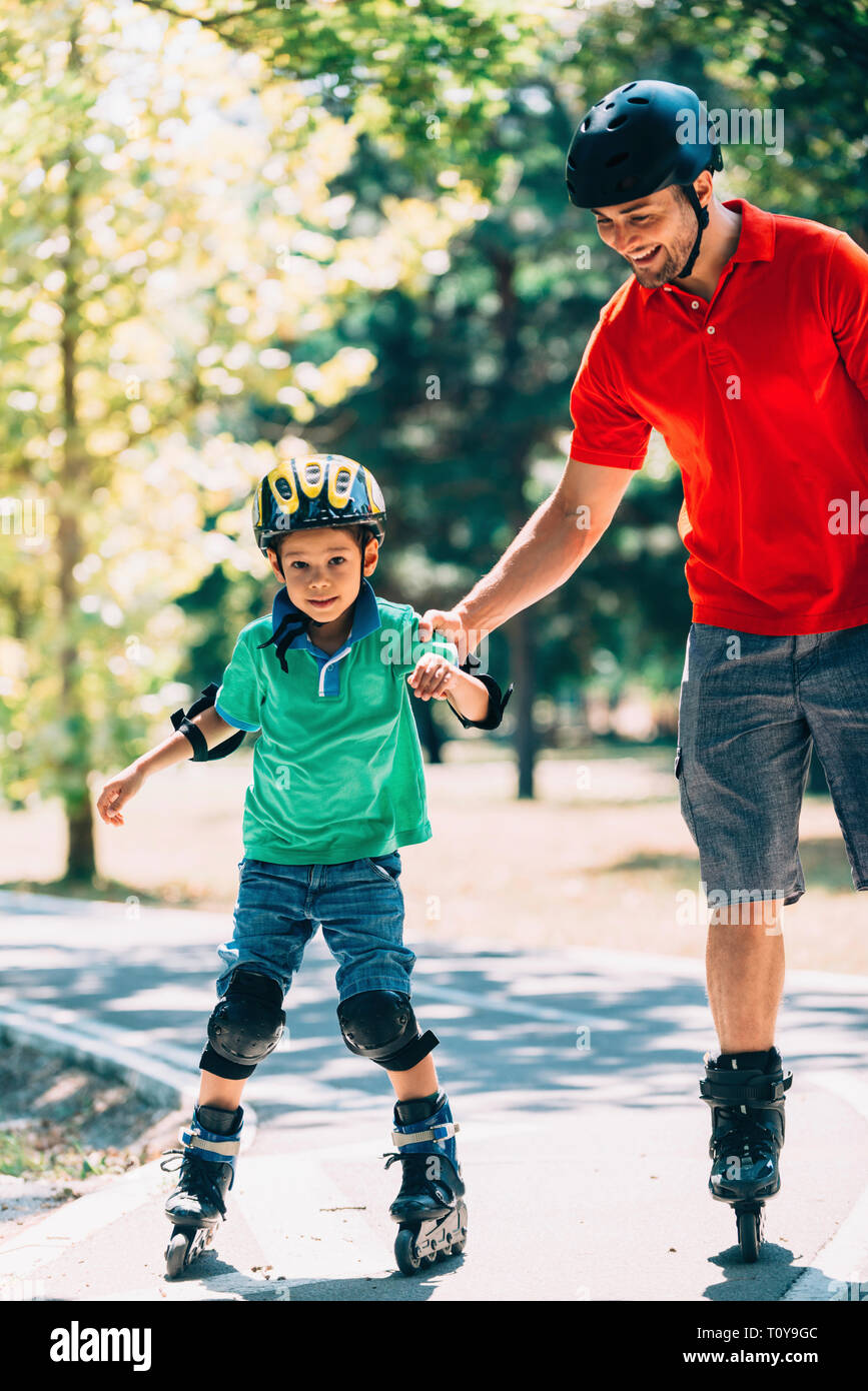Vater lehre Sohn Skaten in Park. Stockfoto Vater lehre Sohn Skaten in Park. Stockfoto