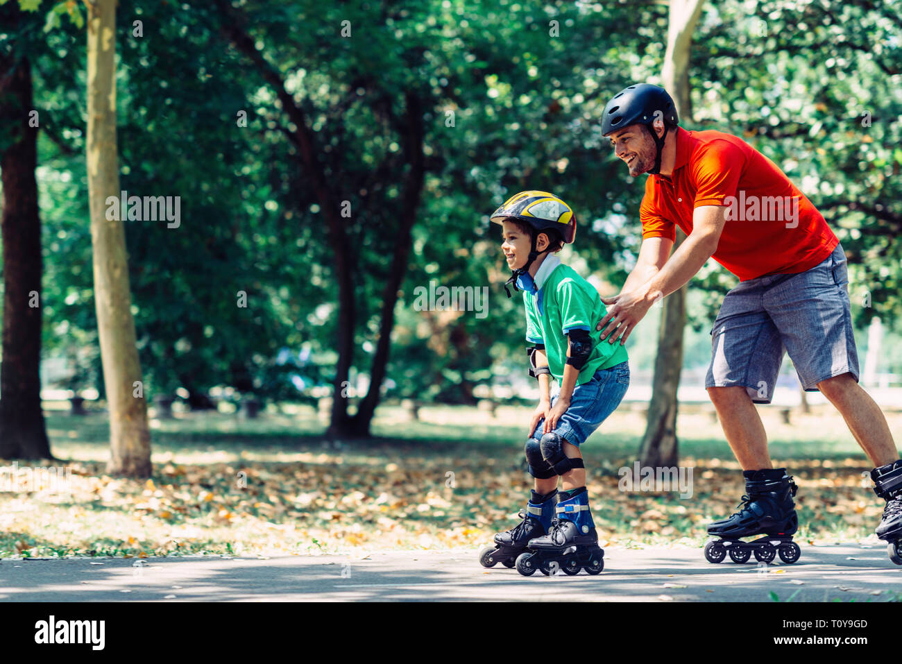 Vater und Sohn Skaten in Park. Stockfoto Vater und Sohn Skaten in Park. Stockfoto