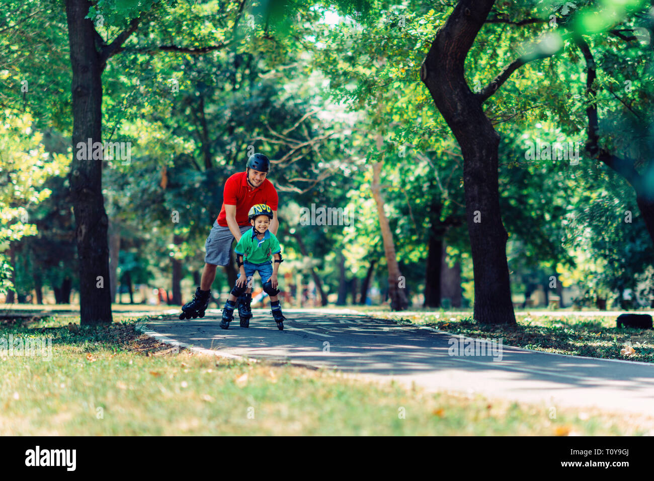 Vater lehre Sohn Skaten in Park. Stockfoto Vater lehre Sohn Skaten in Park. Stockfoto