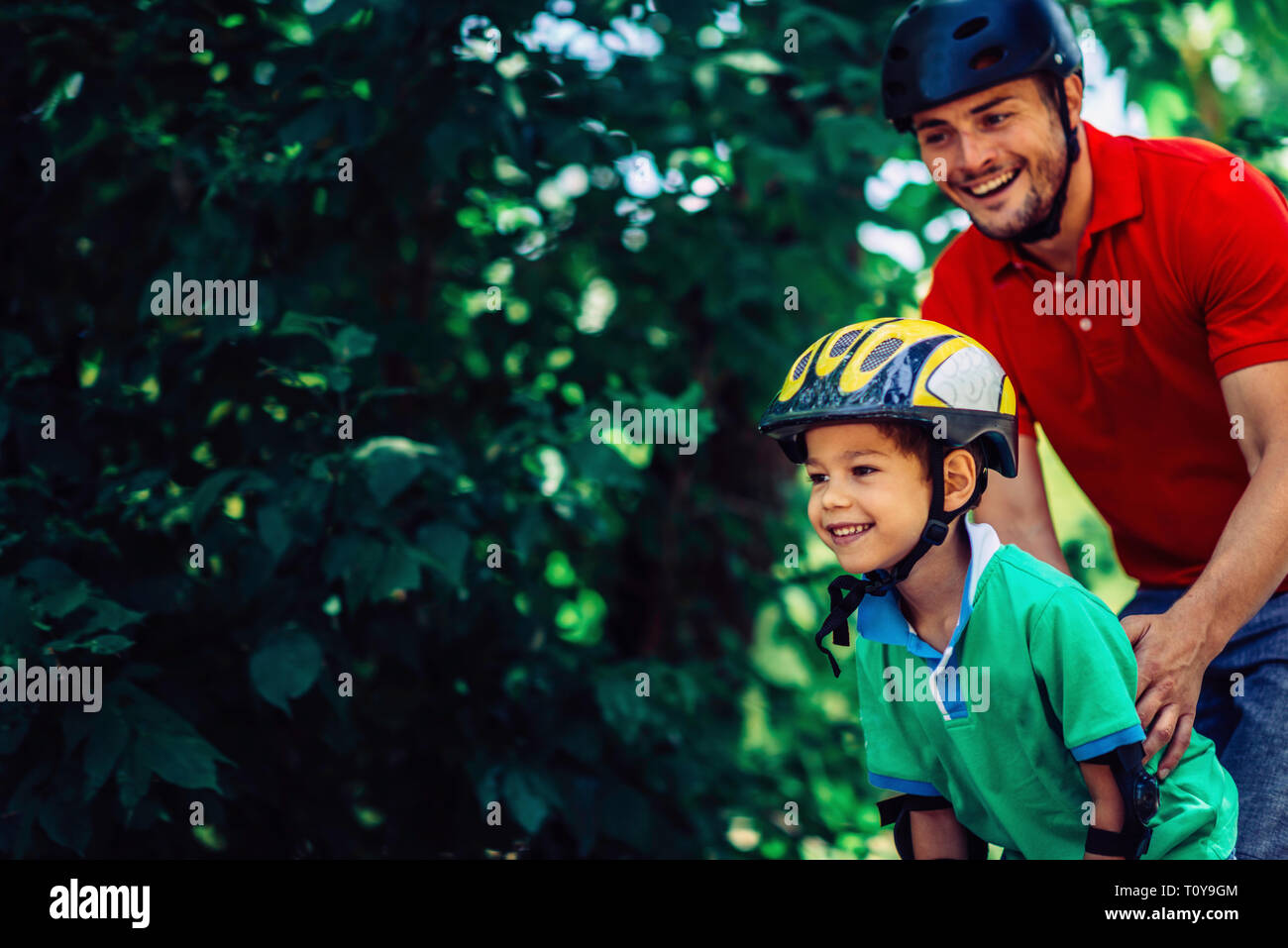 Vater lehre Sohn Skaten in Park. Stockfoto Vater lehre Sohn Skaten in Park. Stockfoto