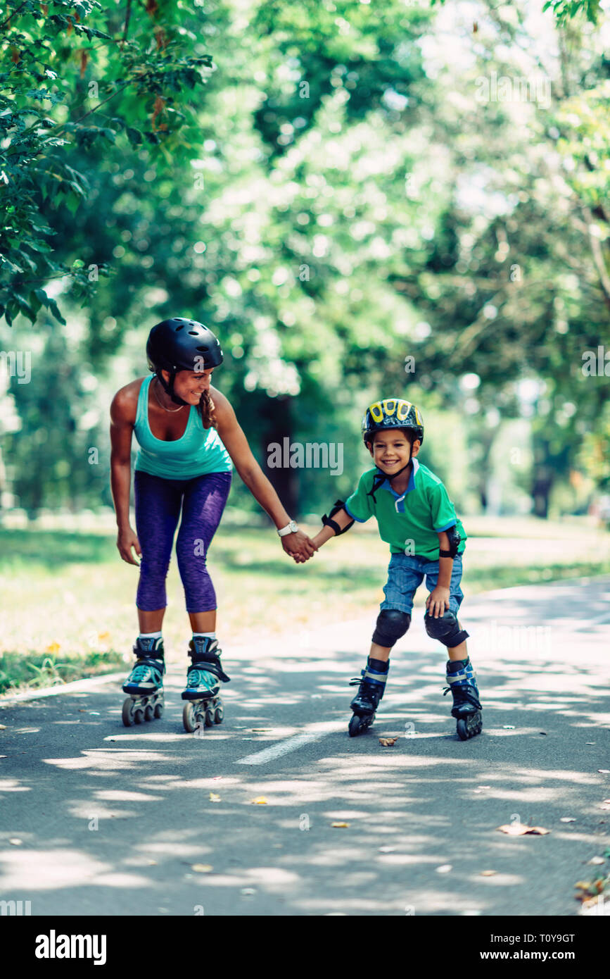 Mutter lehre Sohn Skaten in Park. Stockfoto Mutter lehre Sohn Skaten in Park. Stockfoto