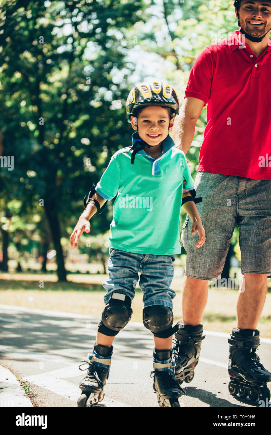 Vater Skaten im Park mit Sohn. Stockfoto Vater Skaten im Park mit Sohn. Stockfoto