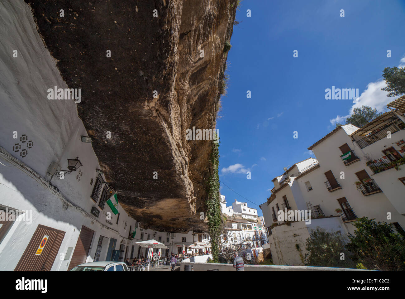 Setenil, Spanien - 4. März, 2019: Straße mit Wohnungen in Felsen Überhänge gebaut. Setenil de las Bodegas, Cadiz, Andalusien, Spanien. Restaurant des sonnigen Höhlen Stockfoto