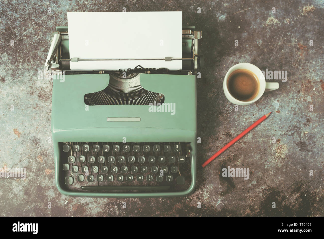 Alte Schreibmaschine neben einer Tasse Kaffee gegen Grunge Hintergrund Stockfoto
