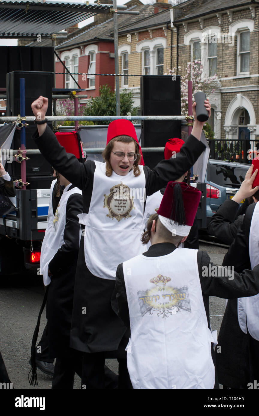 Chassidischen jungen junge Männer in Fancy Dress in Stamford Hill tanzen und singen und sammeln für wohltätige Zwecke auf der jüdische Feiertag Purim Stockfoto