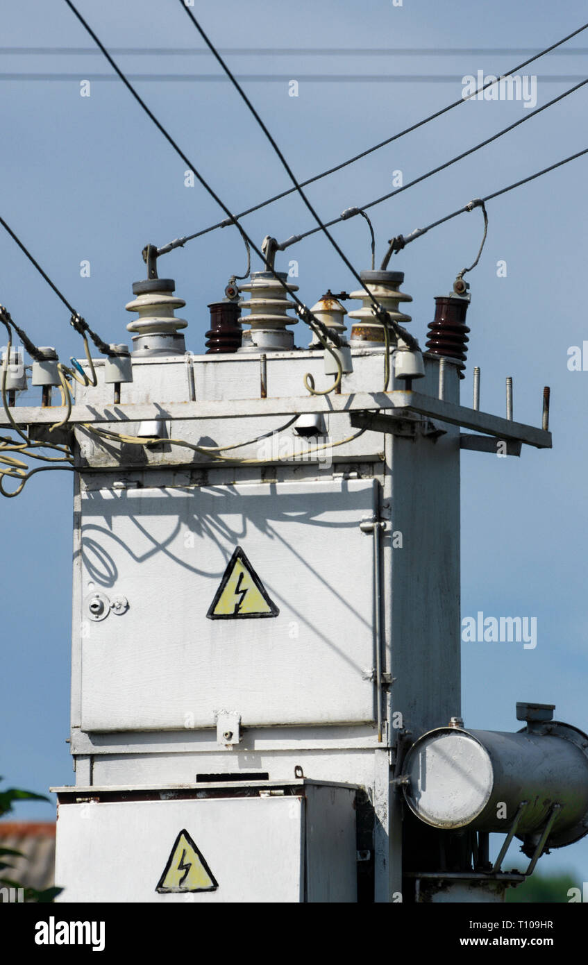 Power System mit elektrischen Bedienfeld mit Warnung Stromschlaggefahr Zeichen'' auf dem Hintergrund der blauen Himmel close-up Stockfoto