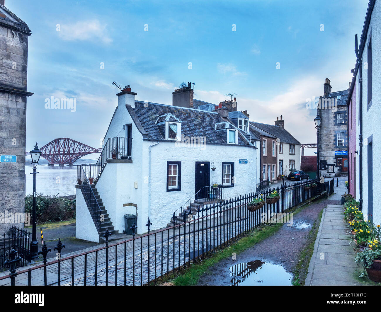 Gebäude entlang der High Street in South Queensferry mit der Forth Bridge hinter Stadt Edinburgh Schottland Stockfoto