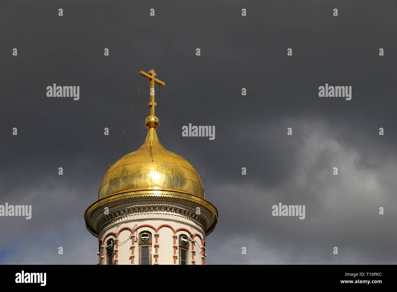 Goldenen Kuppel des christlichen Tempel mit einem Kreuz gegen den Sturm dramatische Himmel mit dunklen Wolken. Orthodoxe Kirche, Hintergrund für religiöse Karte Stockfoto