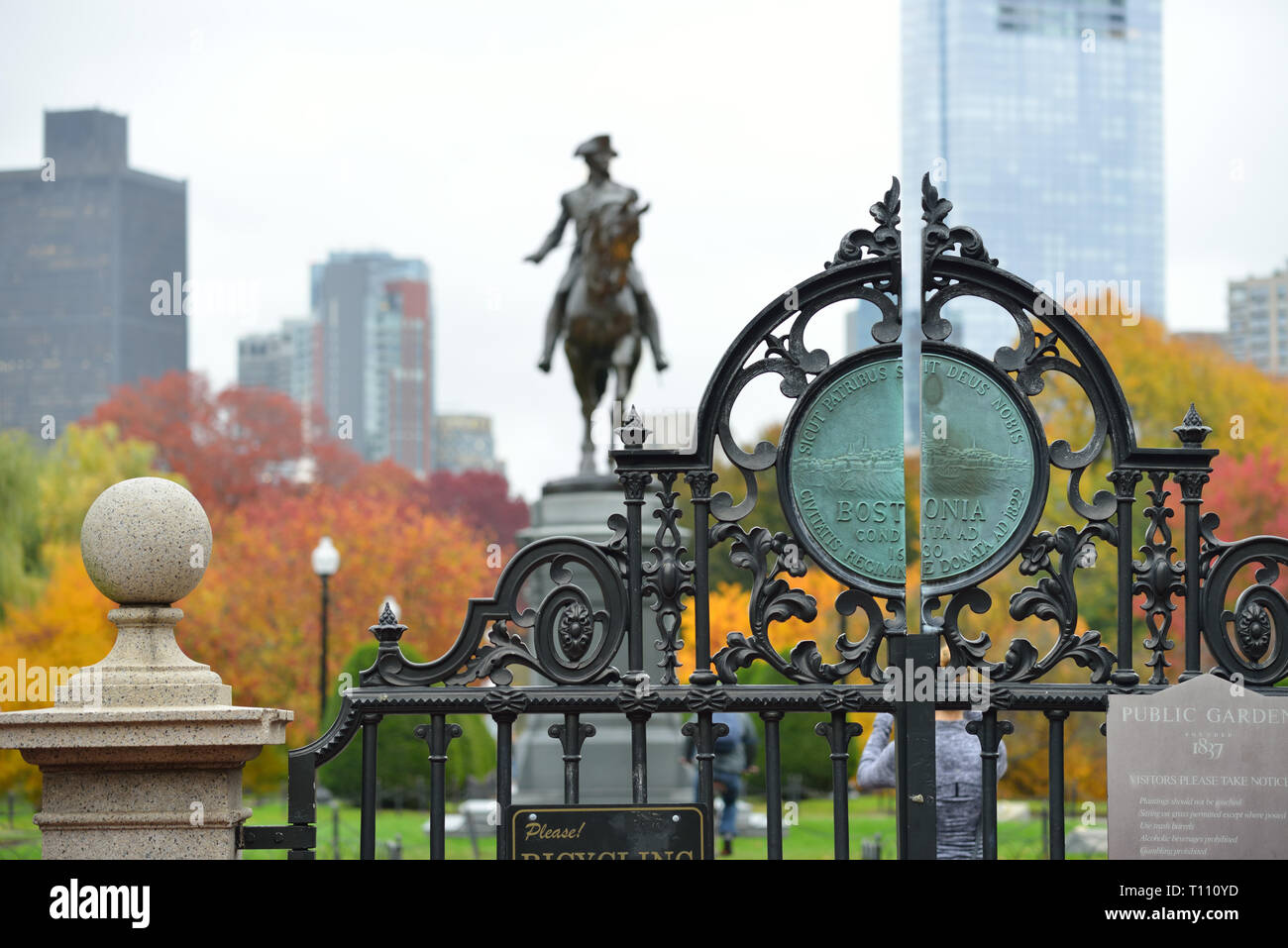 Arlington Tor und die Farben des Herbstes in Boston Public Garden. George Washington Statue und City Skyline im Hintergrund. Stockfoto