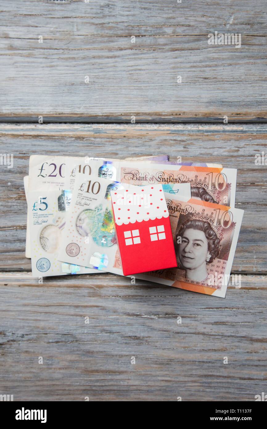 Gehäuse kosten. Papier Spielzeug Haus mit britischen Banknoten Stockfoto