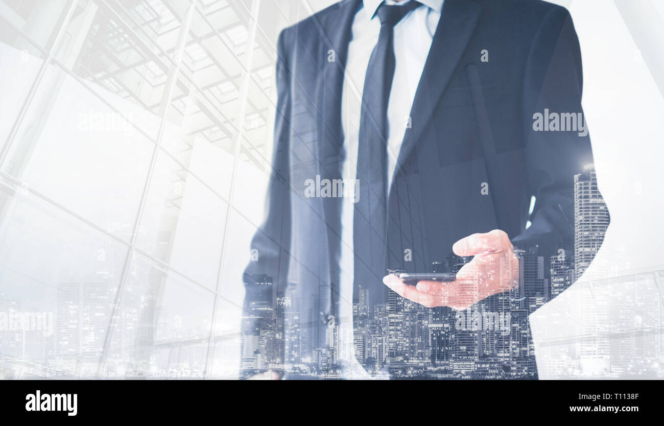 Business Mann mit Anzug holding Handy Double Exposure mit Stadt Hintergrund Stockfoto