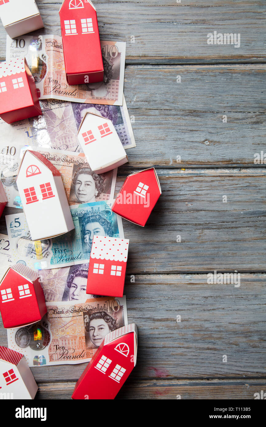 Gehäuse kosten. Papier Spielzeug Haus mit britischen Banknoten Stockfoto