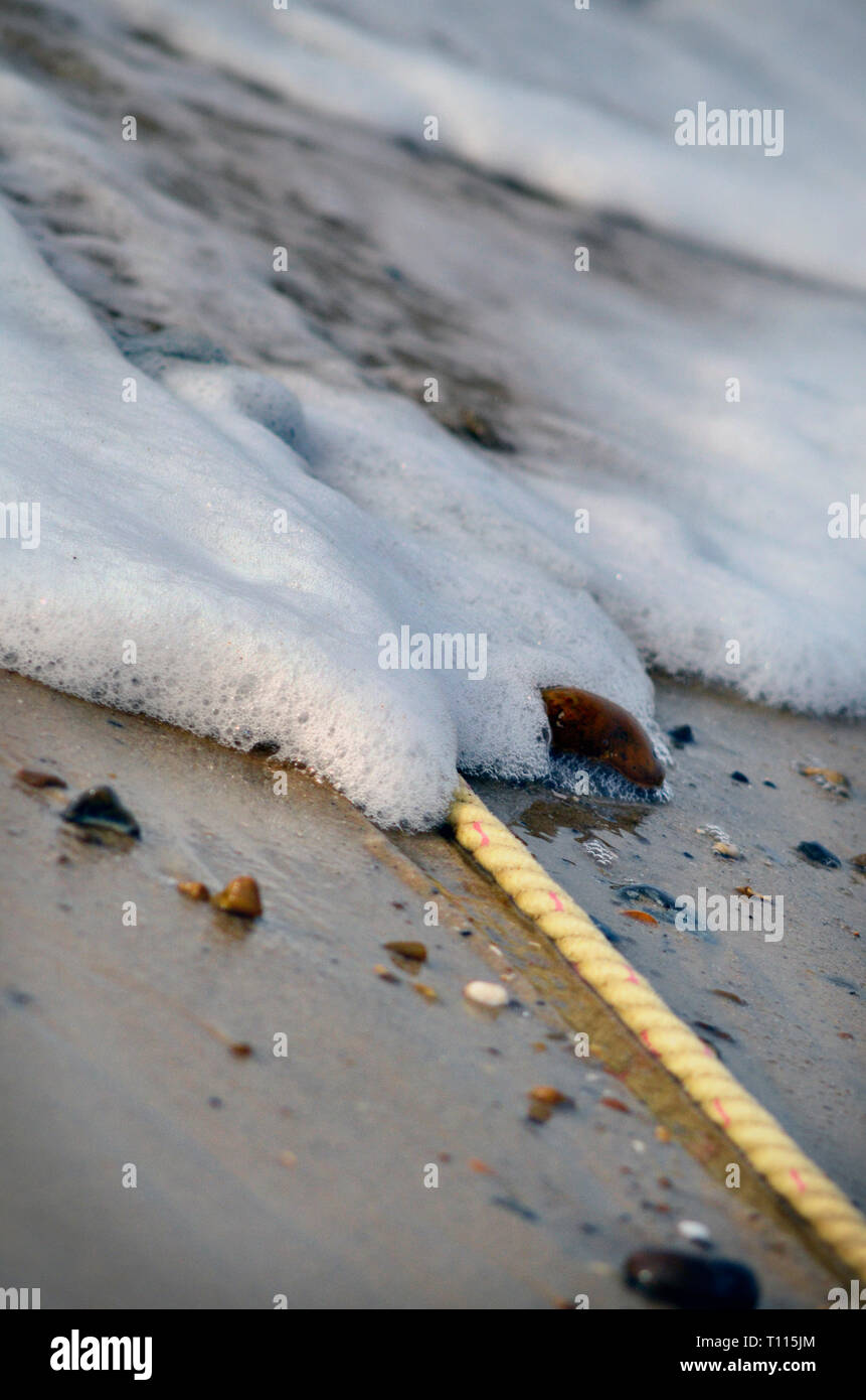 Eingehende surfen auf steinigem Strand Stockfoto