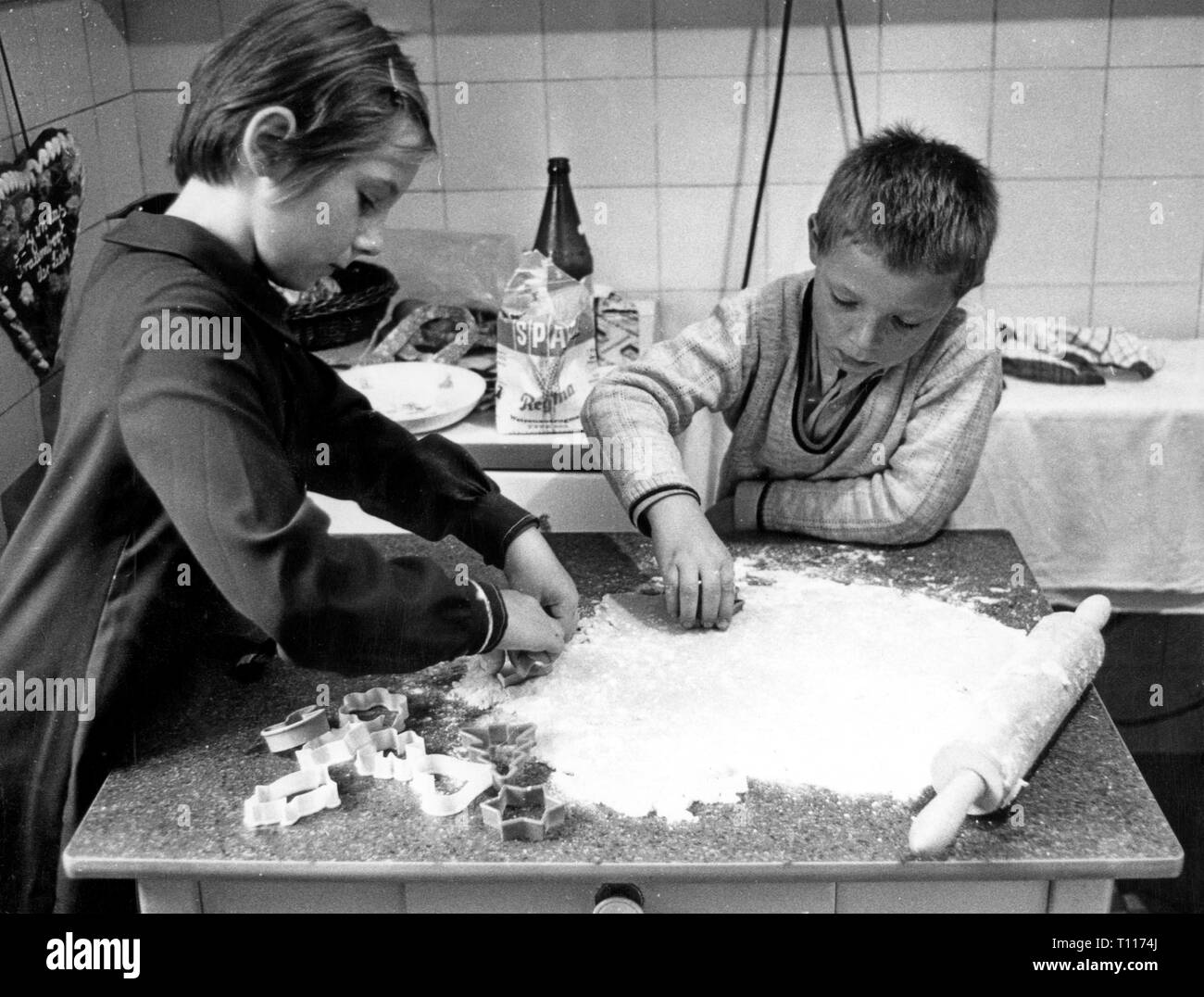 Haushalt, Kochen und Backen, zwei Kinder schneiden Weihnachtsgebäck, 1970, Additional-Rights - Clearance-Info - Not-Available Stockfoto