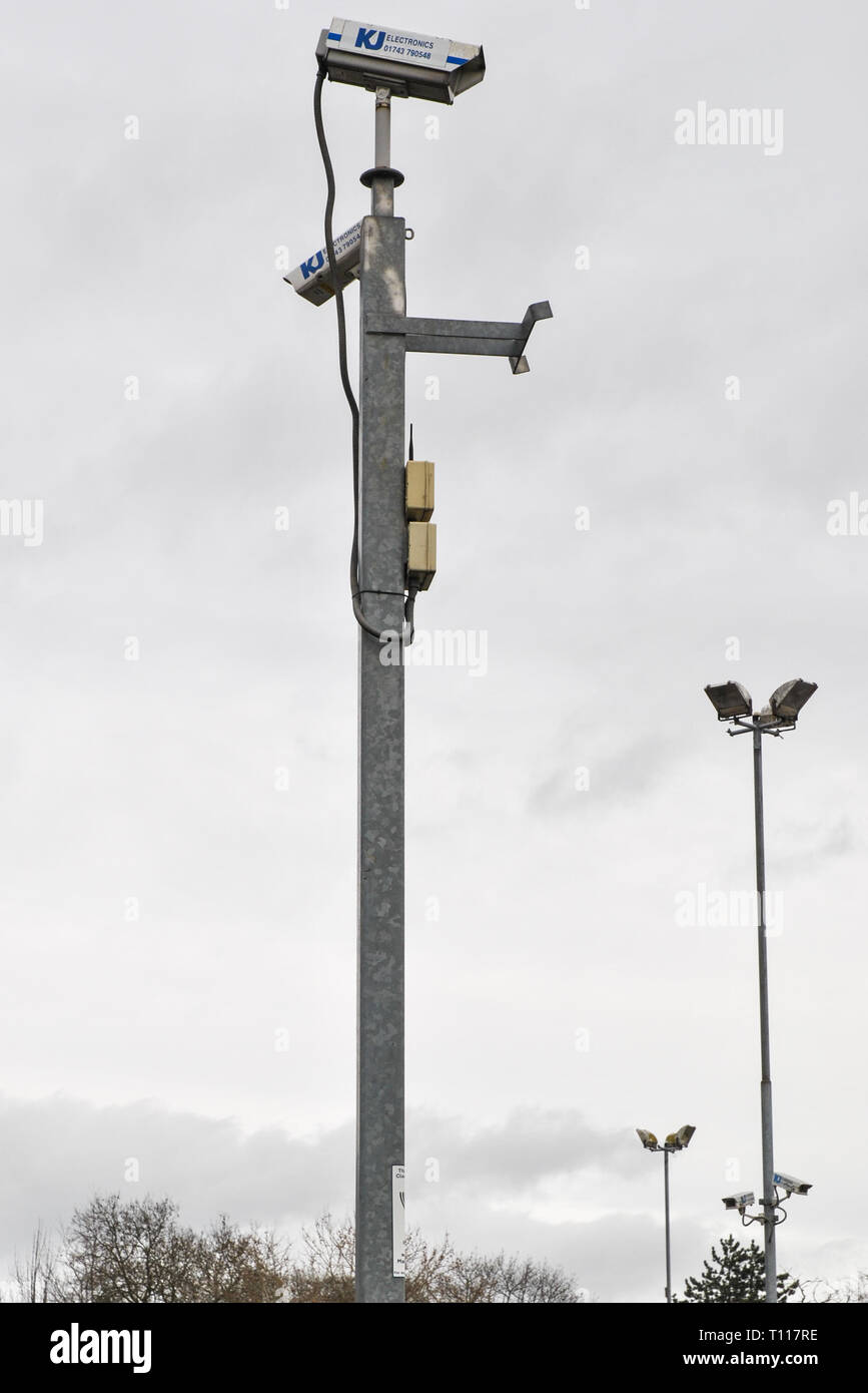 Überwachungskameras auf Stahl Beiträge gegen einen grauen Himmel Stockfoto
