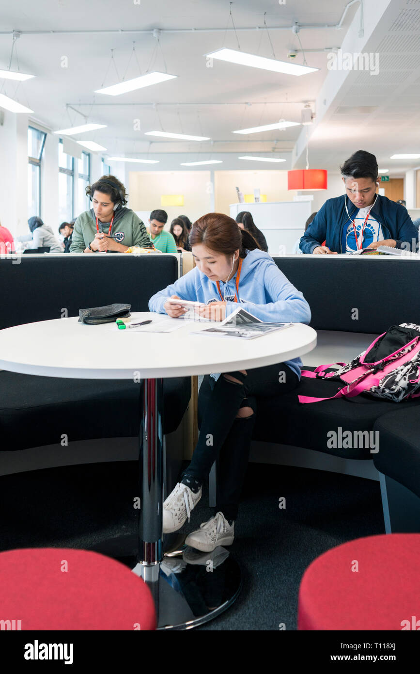 Die Schüler sitzen und arbeiten in der Schule/Hochschule Bibliothek zu überarbeiten Stockfoto