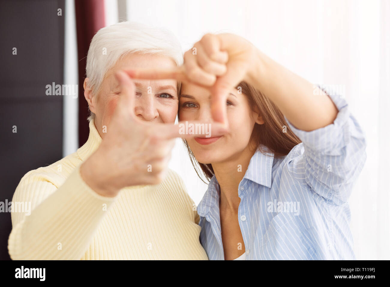Glückliche Mutter und Tochter, die Rahmen mit den Fingern Stockfoto