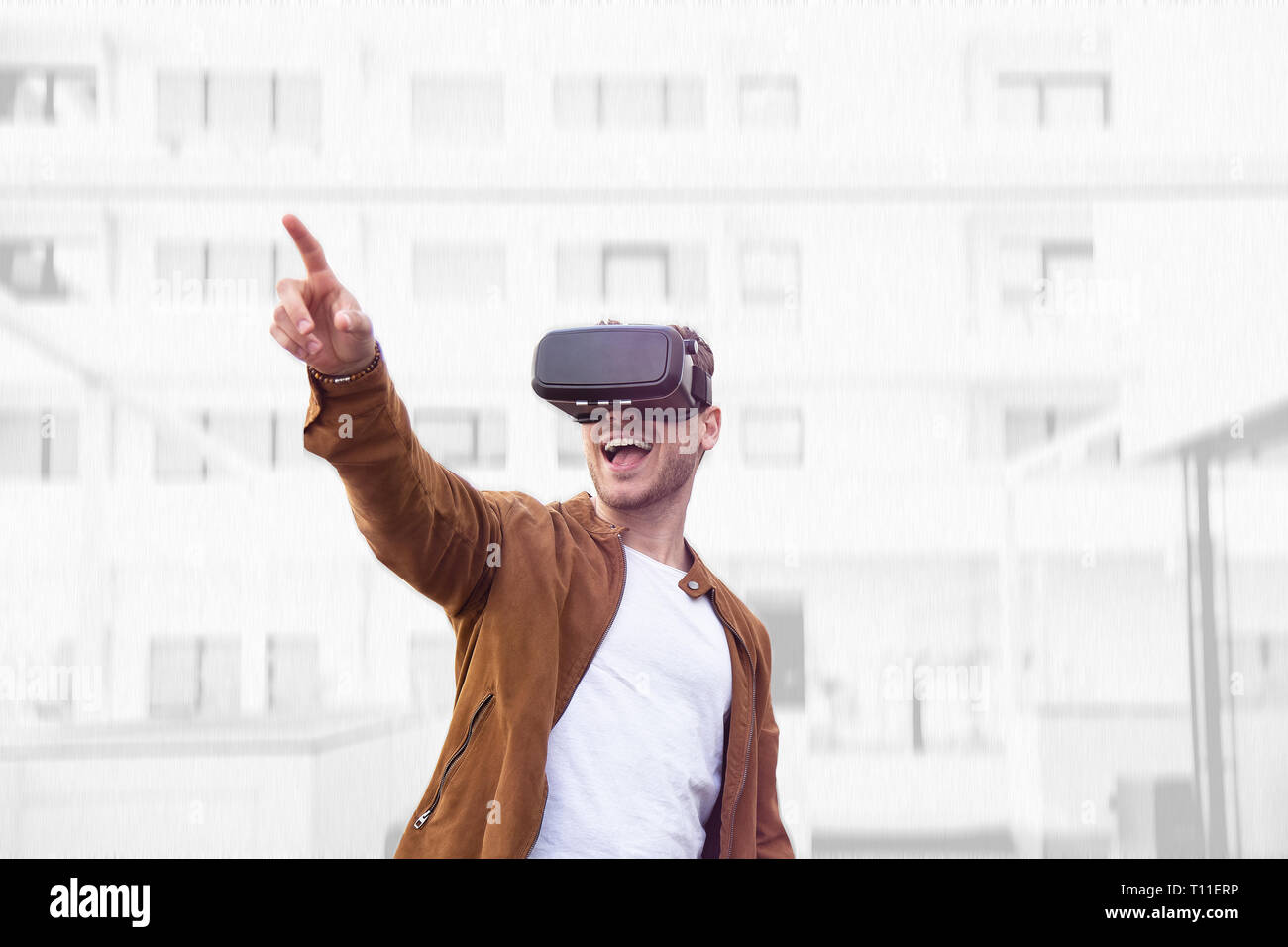 Fröhlich junger Erwachsener charmanter Mann mit VR Virtual Reality Brillen mit Draw Hintergrund Stockfoto