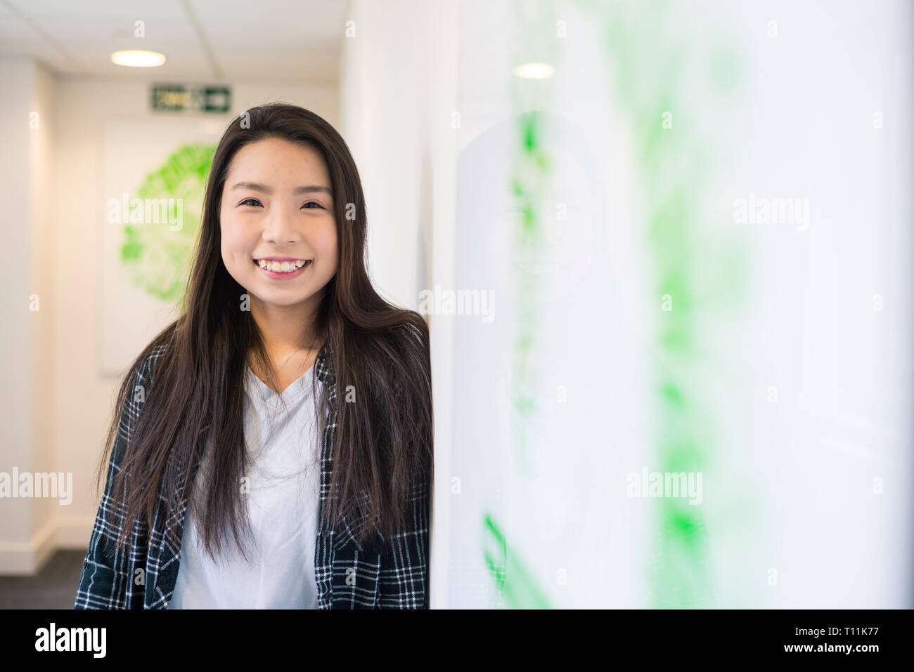 Eine junge Südostasiatische Frau steht im Flur eines Cambridge College. Stockfoto