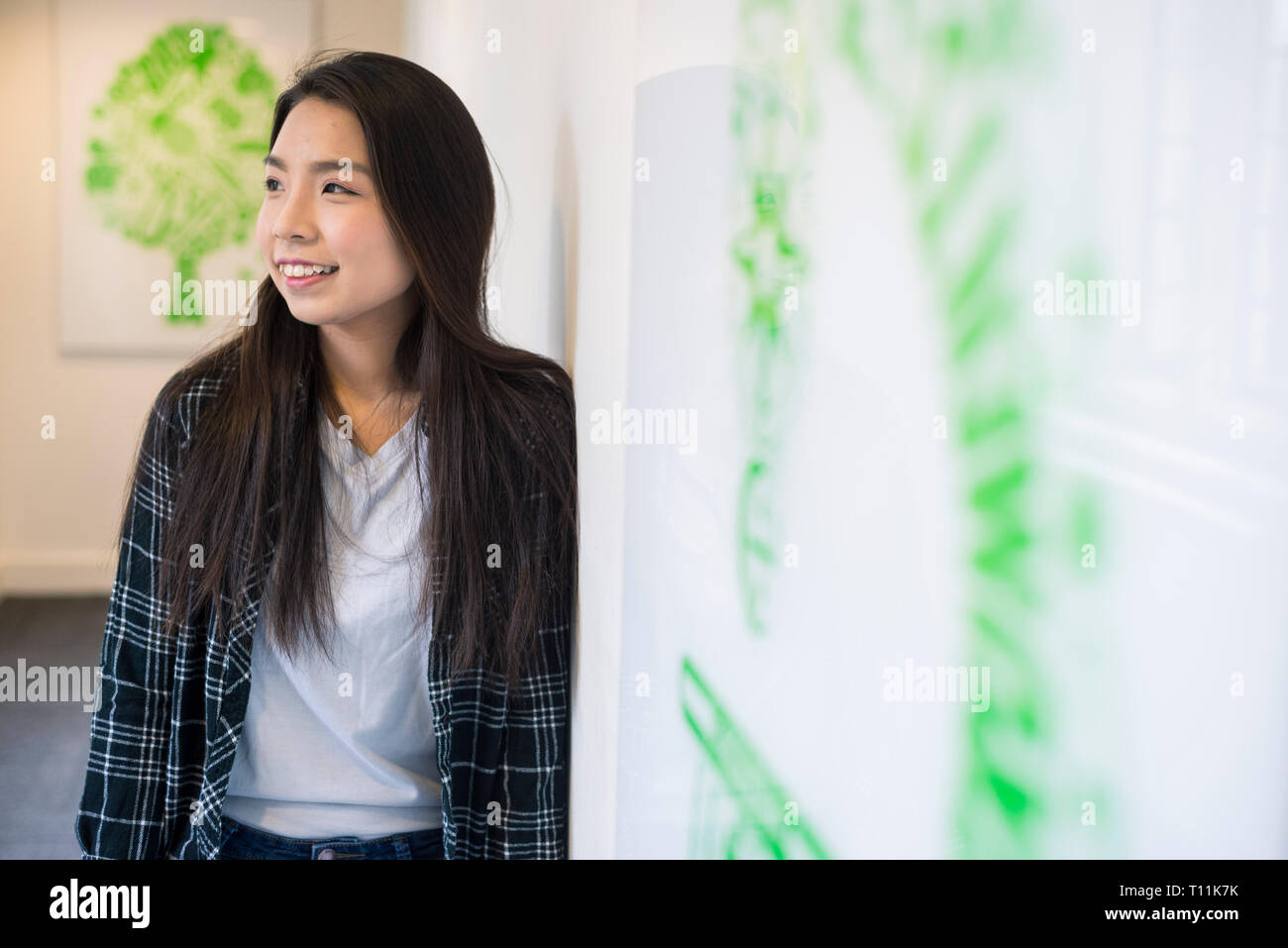 Eine junge Südostasiatische Frau steht im Flur eines Cambridge College. Stockfoto