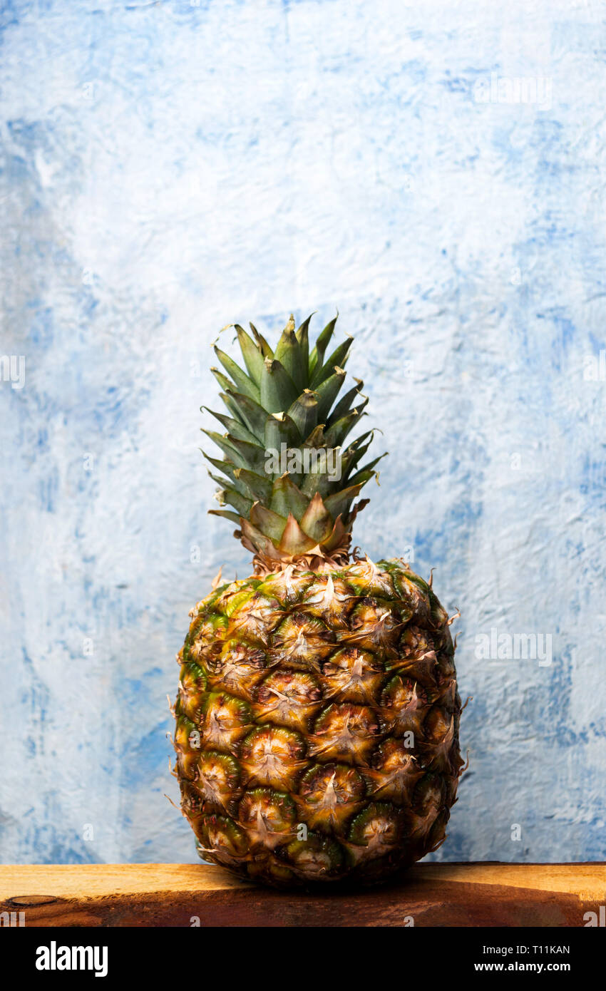 Ganze Ananas Frucht vor einem blauen Hintergrund Stockfoto