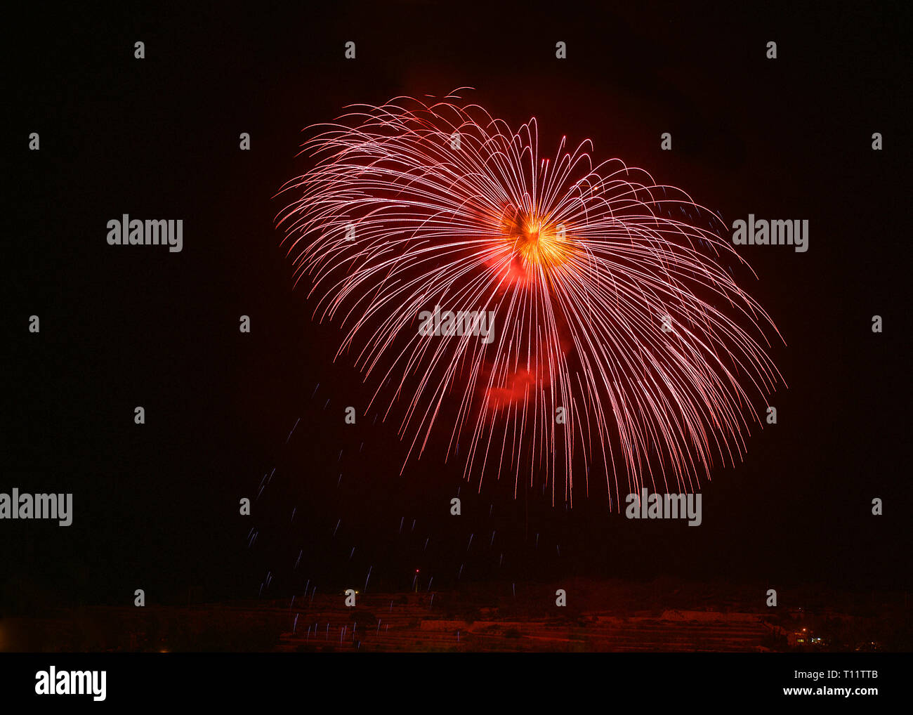 Feuerwerk, bunten Feuerwerk am schwarzen Himmel Hintergrund, Fireworks Explosion in den dunklen Himmel mit Stadt silouthe auf der Unterseite, Feuerwerk auf Malta Stockfoto