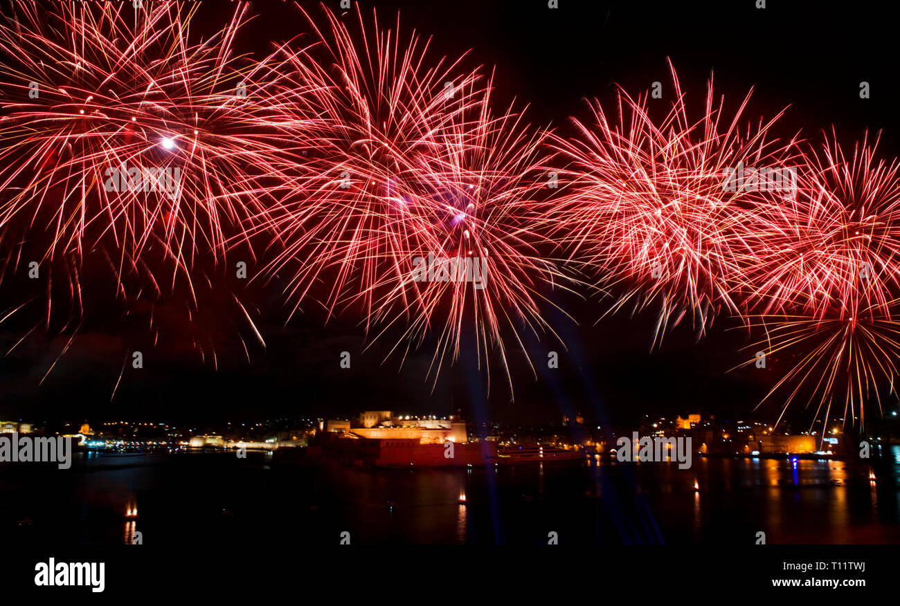 Feuerwerk, bunten Feuerwerk am schwarzen Himmel Hintergrund, Fireworks Explosion in den dunklen Himmel mit Stadt silouthe auf der Unterseite, Feuerwerk auf Malta Stockfoto