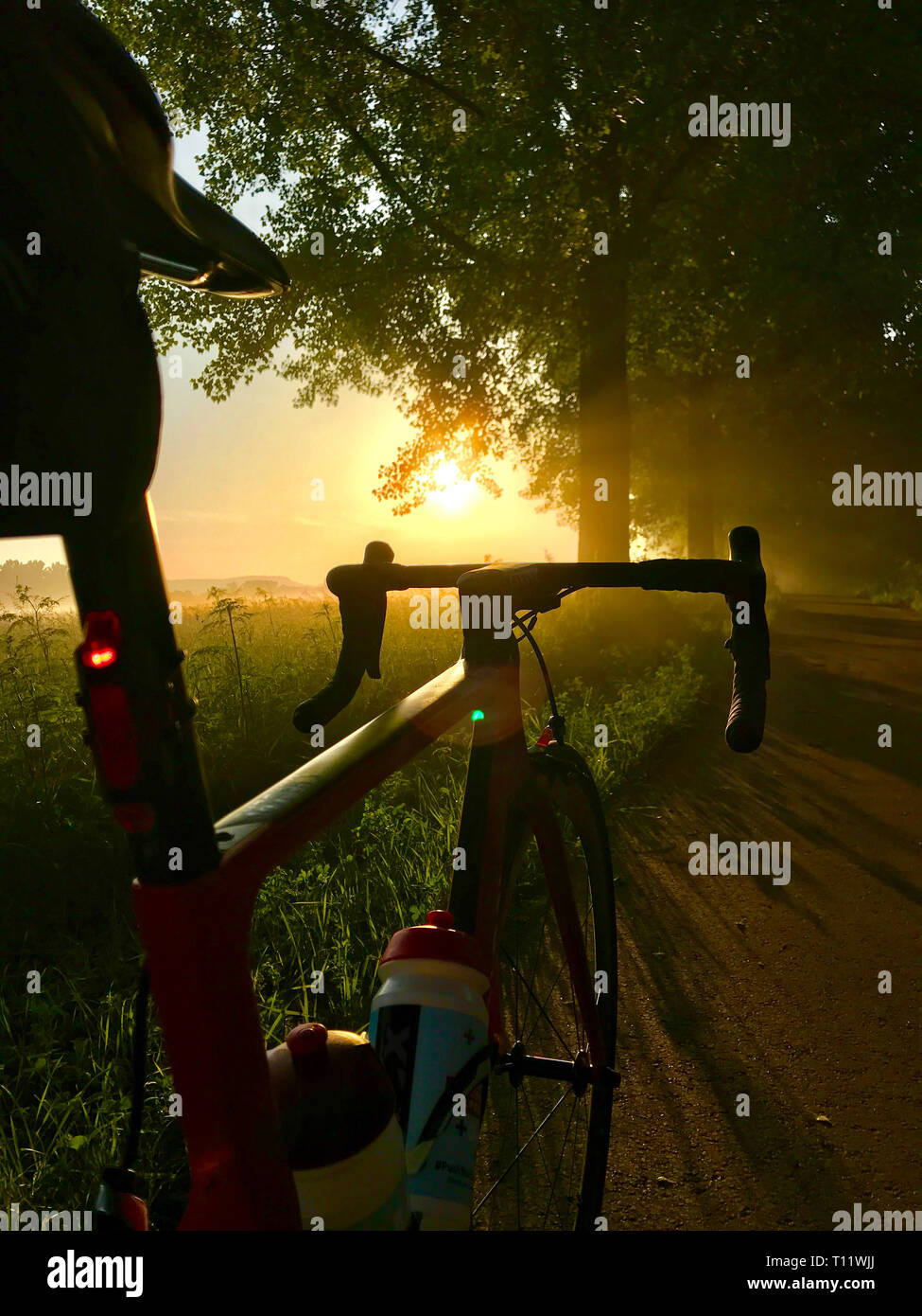 Road Bike in den ersten Sonnenstrahlen des Tages bei Sonnenaufgang Stockfoto