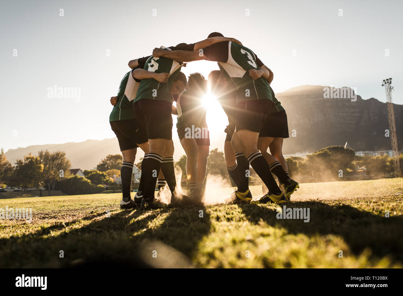 Das rugby-Team steht in einer Keule und reibt sich die Füße auf dem Boden. rugby-Team feiert den Sieg. Stockfoto