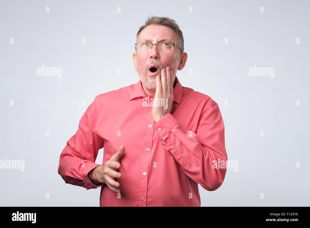 Älterer Mann im roten T-Shirt Zahn Schmerzen leiden. Er muss zum Arzt. Stockfoto