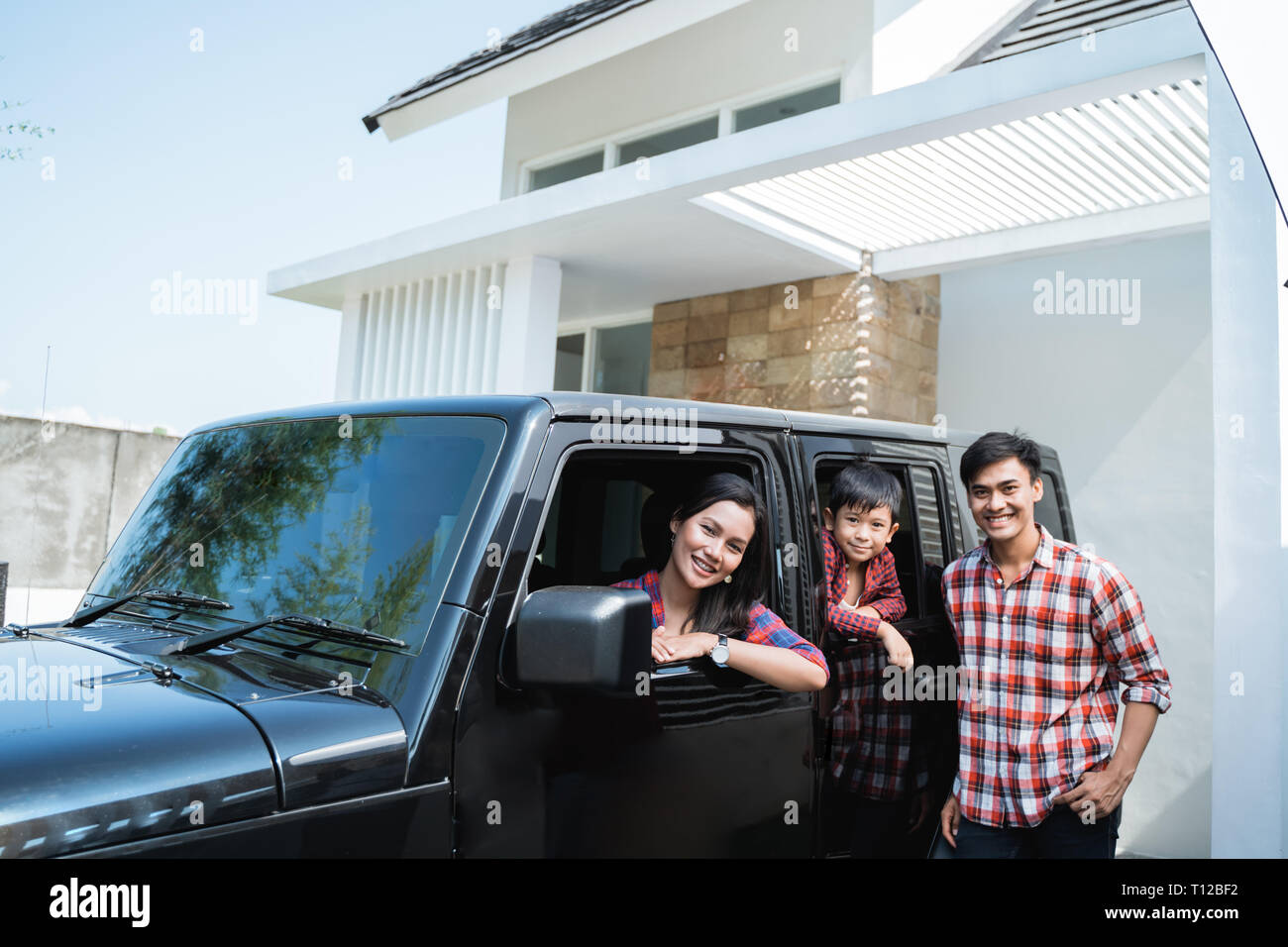 Familie mit Kind im Auto im Auto Port Ihres Hauses sitzen Stockfoto