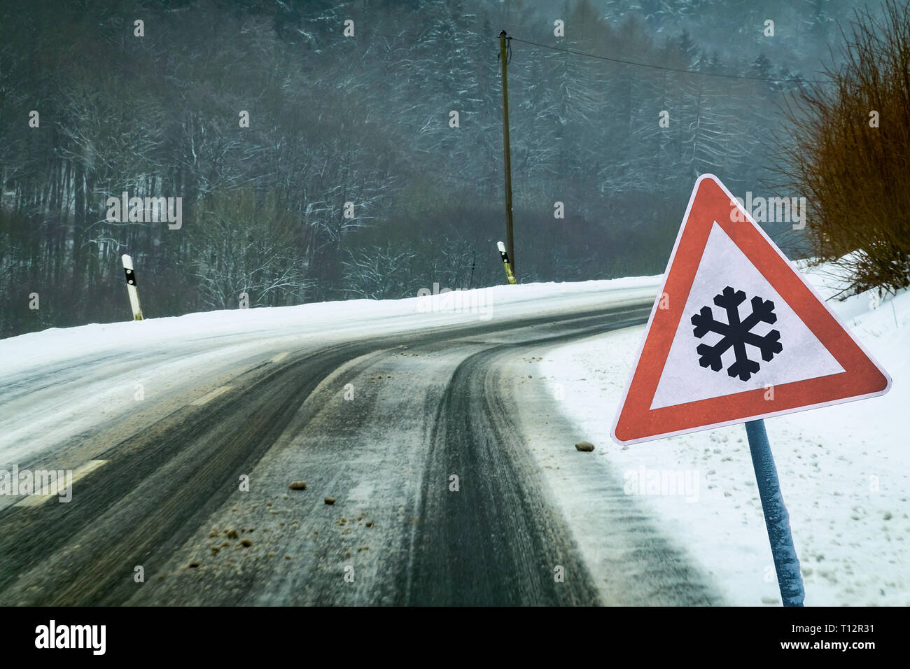 Snowy kurvigen Strasse mit verkehrsschild Snowy kurvigen Strasse mit Verkehrsschild Stockfoto