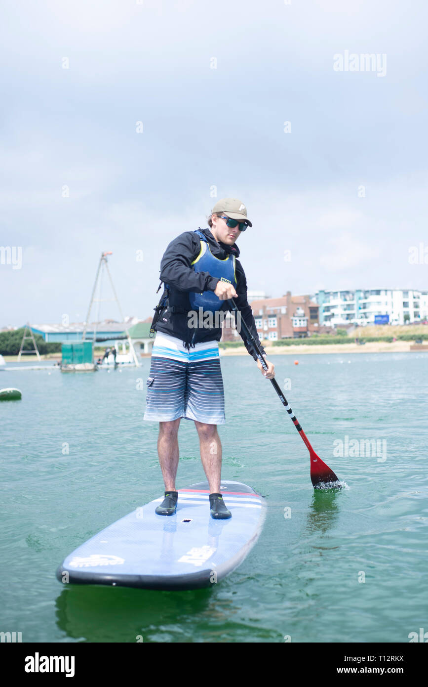 Ein Mann stand up Paddle Boarder bei Hove Lagune Stockfoto