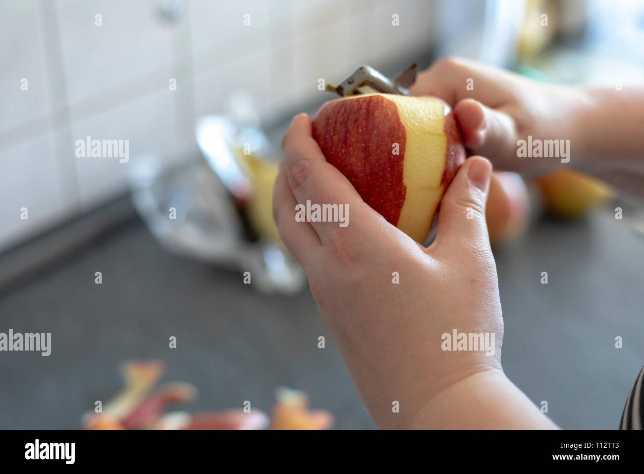 Hände Peeling ein Kochen Apple auf grauem Hintergrund Stockfoto