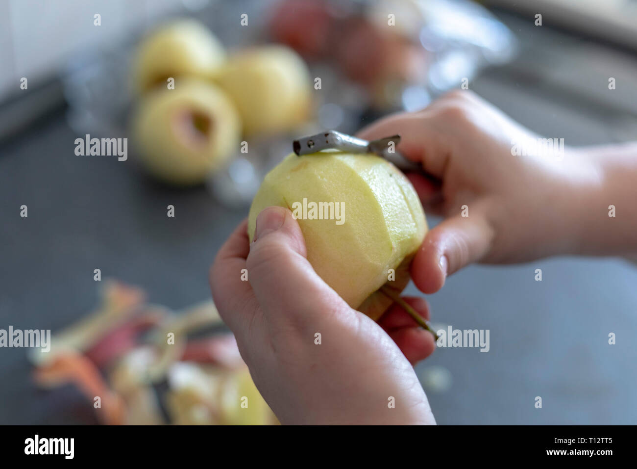 Hände Peeling ein Kochen Apple auf grauem Hintergrund Stockfoto