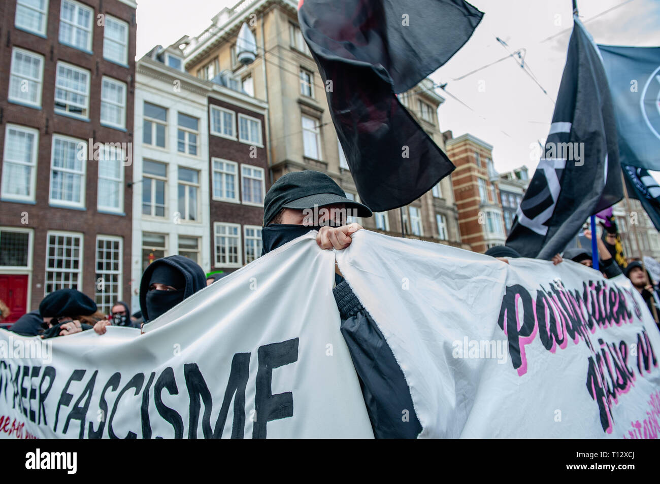 Ein Mann wird gesehen, bedeckte sein Gesicht, während Sie zwei Antifa große Banner während der Demonstration. Tausende von Menschen an den Dam Platz im Zentrum von Amsterdam versammelt, um gegen Rassismus und Diskriminierung zu demonstrieren. Sie bitten um Vielfalt und Solidarität, gegen alle Formen von Rassismus und Diskriminierung. Auch gegen die beiden politischen Parteien der extremen Rechten in den Niederlanden, die Pvv und der FvD, die ihre Macht während der letzten Wahlen im Land zugenommen haben. Eine kleine rechtsextreme Gruppe zeigte sich während der Wanderung zwei große Plakate und Schreien bei den Demonstranten. Stockfoto