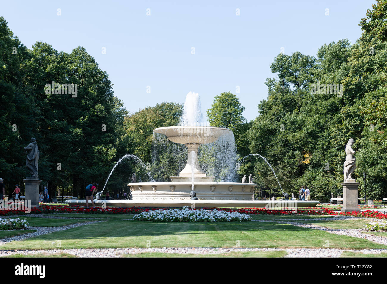 Warschau, Polen - 23. August 2018: Touristen durch Brunnen weißen Blüten im Sommer Saxon Gardens Park mit Spritzen spritzen Skulpturen Stockfoto