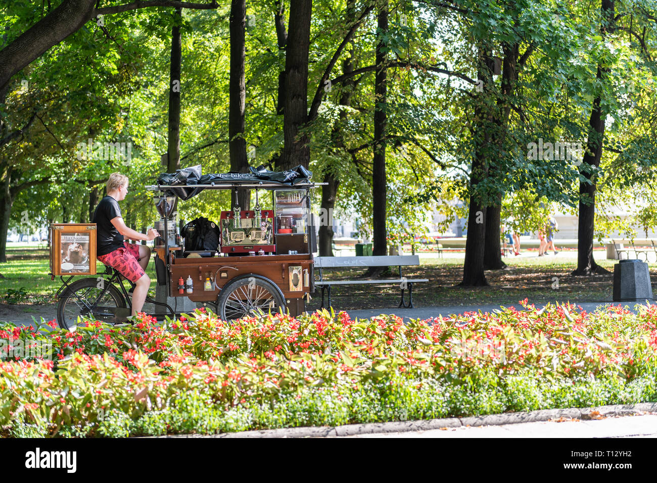 Warschau, Polen - 23 August, 2018: Der junge Mann reiten Fahrrad heiße Schokolade fast food Kaffee stand Shop im Sommer Saxon Gardens Park Stockfoto