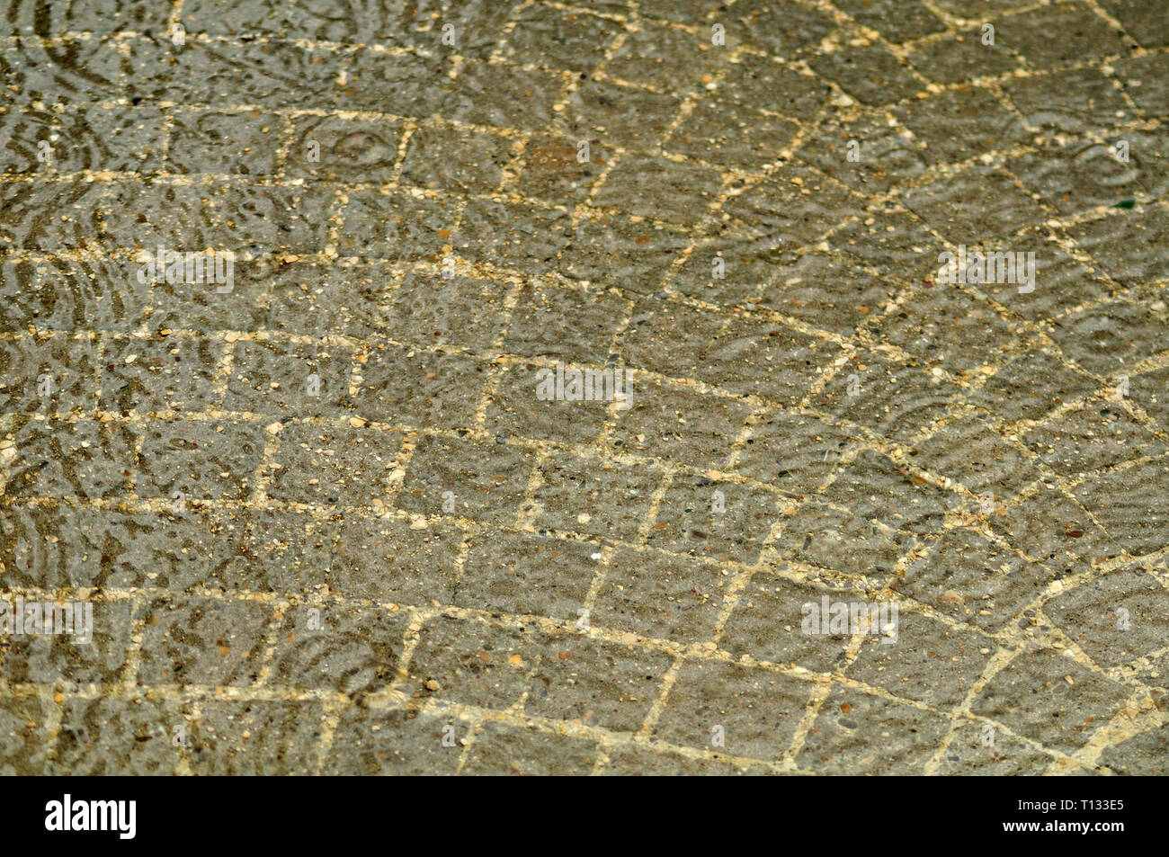 Sett Steine in einem Kreis auf einem Bürgersteig an regnerischen Tag Stockfoto