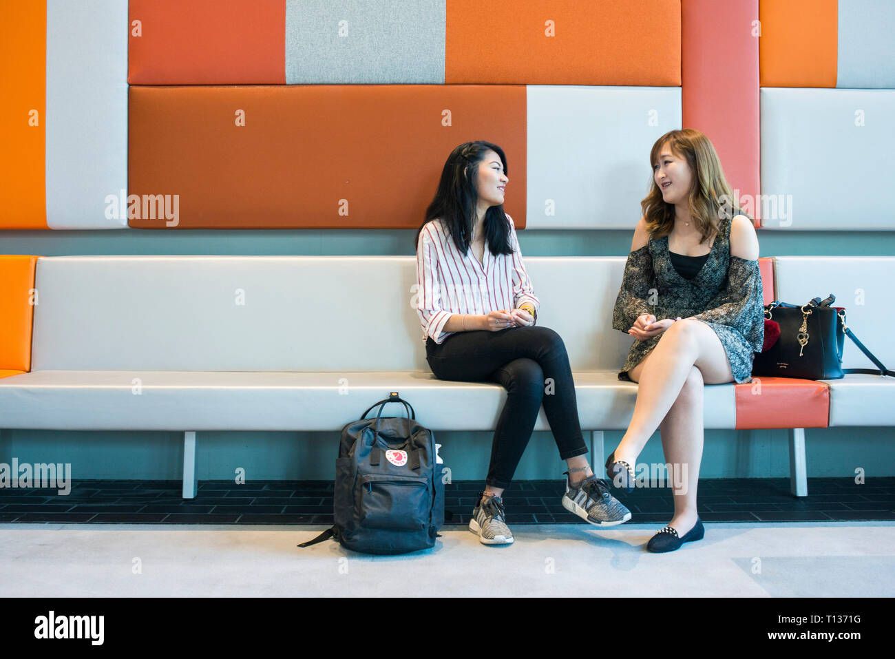 Zwei junge Südostasiatische studierende Sitzen und Plaudern auf dem Campus Stockfoto