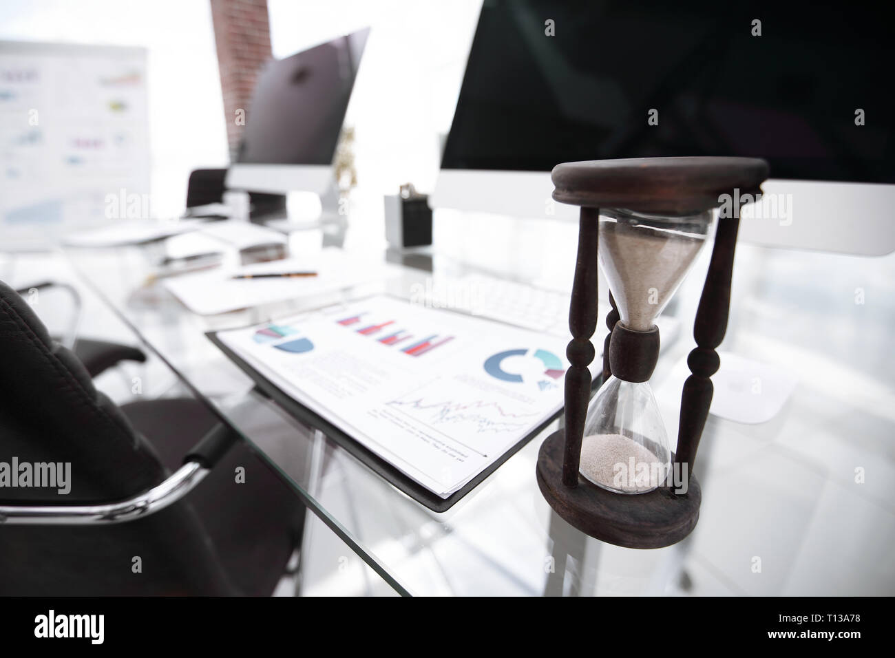 Die Grafik und die Sanduhr auf dem Schreibtisch Stockfoto