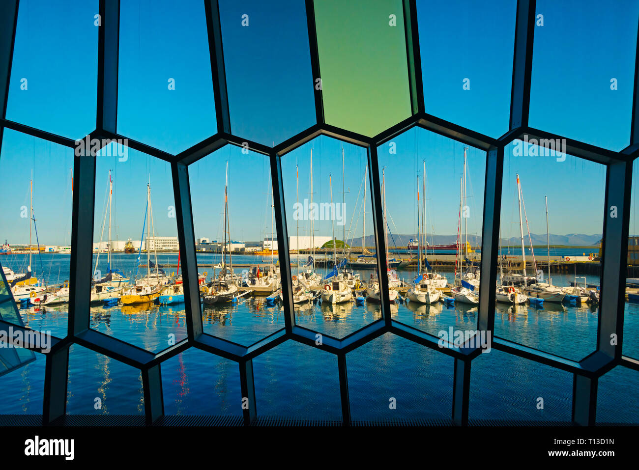Blick auf Segelboote im Alten Hafen durch die Fenster der Harpa Concert Hall & Conference Center, inspiriert durch den Basalt Landschaft von Island, Reykjav Stockfoto