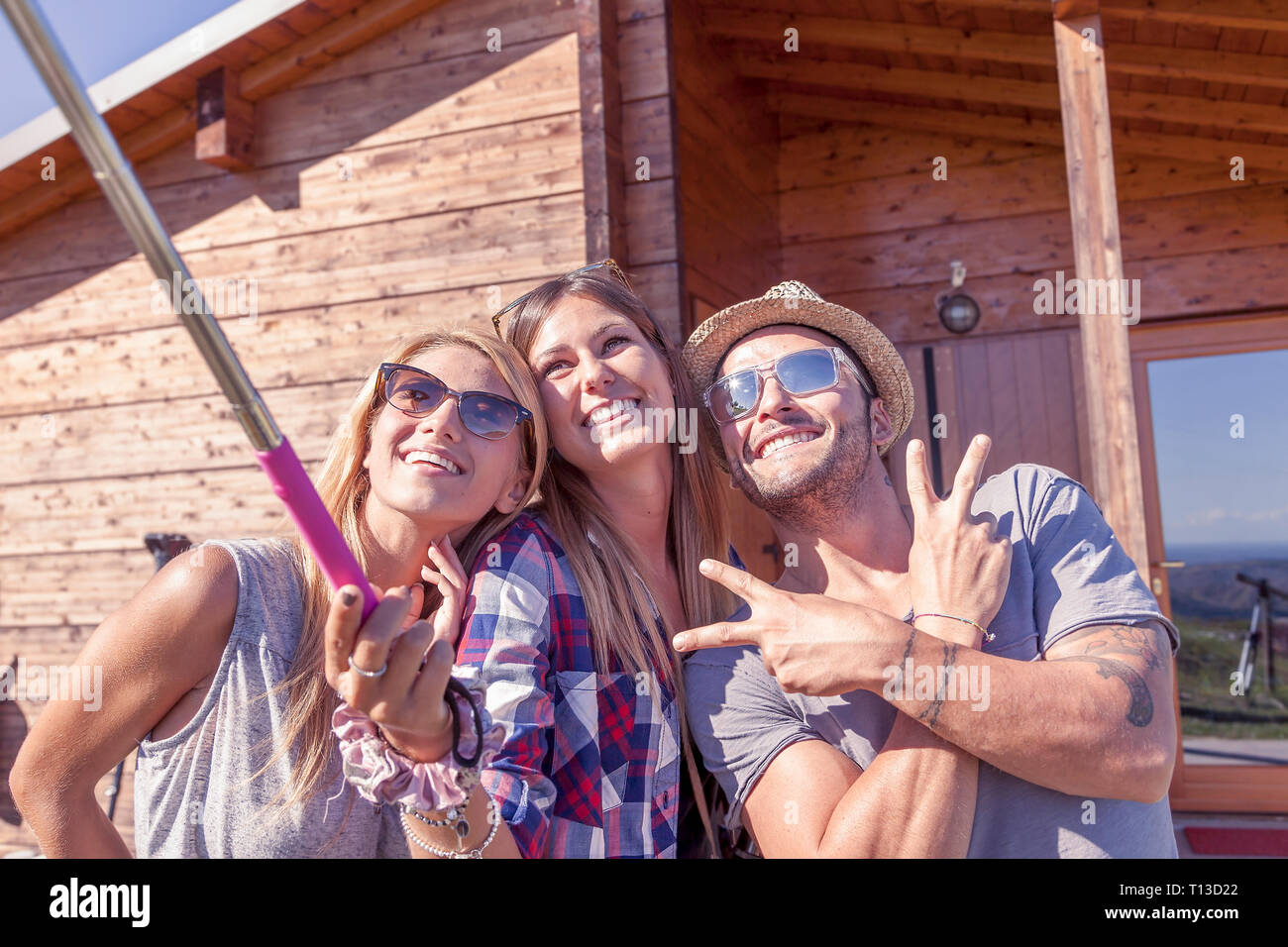 Gruppe von lächelnden Freunde unter Lustig selfie mit Smart Phone auf einem Vintage warmer Farbe gefiltert suchen Stockfoto